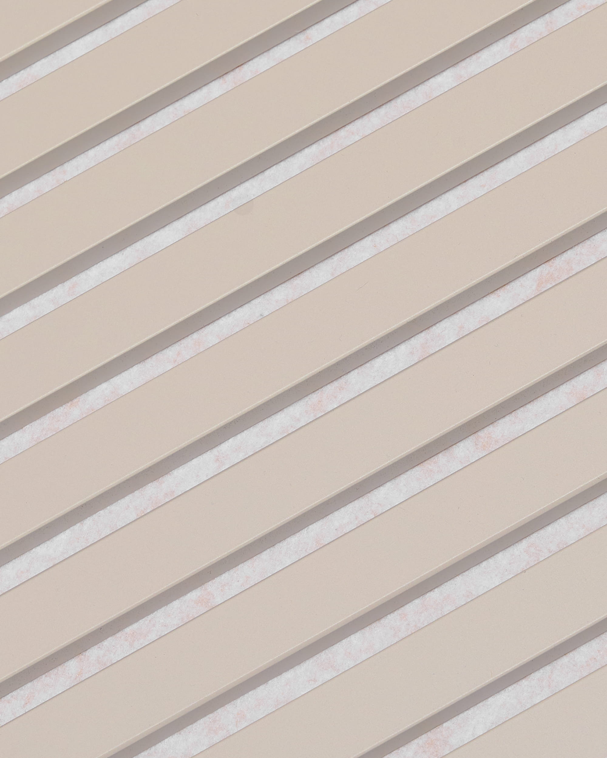 Diagonal beige slats with white gaps form a striped pattern on WoodUpp Akupanel acoustic panel, Soft Linen Light Beige Felt finish, 240x60 cm.
