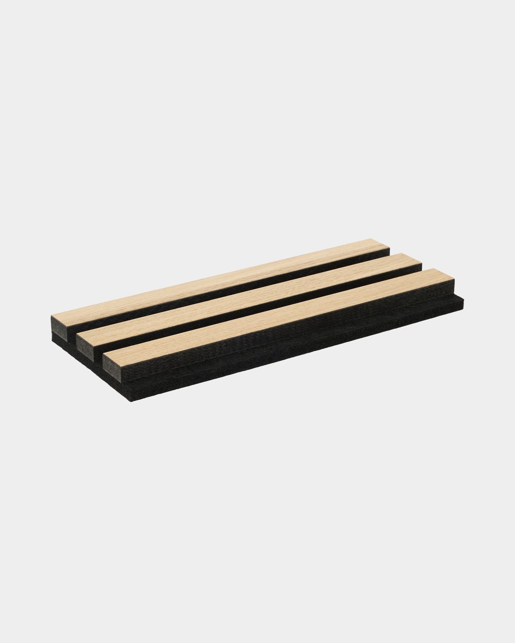 Akupanel sample tray displaying classic oak and black MDF acoustic slats with black felt backing, arranged on a plain white background.