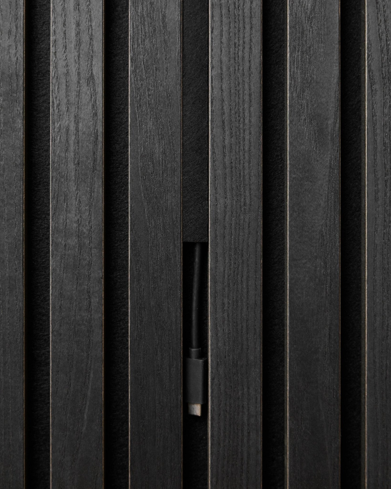 Black WoodUpp Pop-on Cable Covers (3 pcs) conceal cables neatly behind Akupanel acoustic wood panels, maintaining a clean, seamless Nordic look.