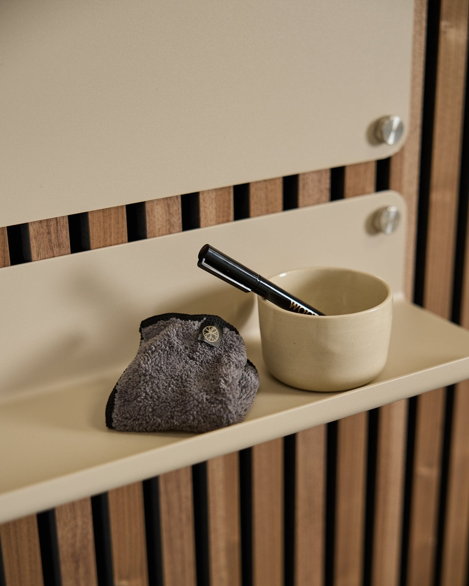The WoodUpp Norr Blackboard set includes a small beige cup, black-handled brush, and cleaning cloth on a beige shelf with Nordic acoustic wood paneling.