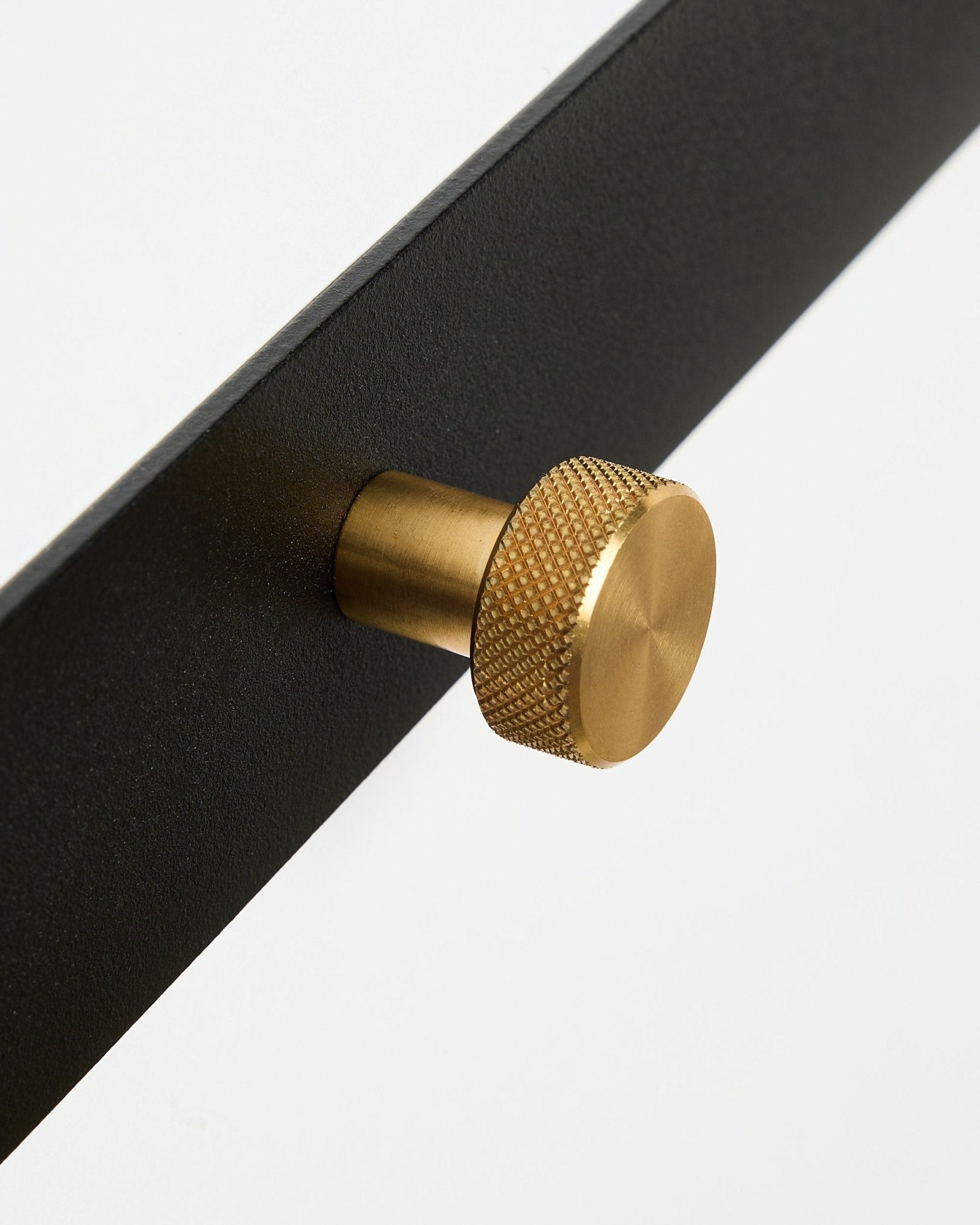 Close-up of the Norr Coat Hook Rack X5 by WoodUpp, featuring black powder-coated steel and round textured brass knobs, set against a white background.