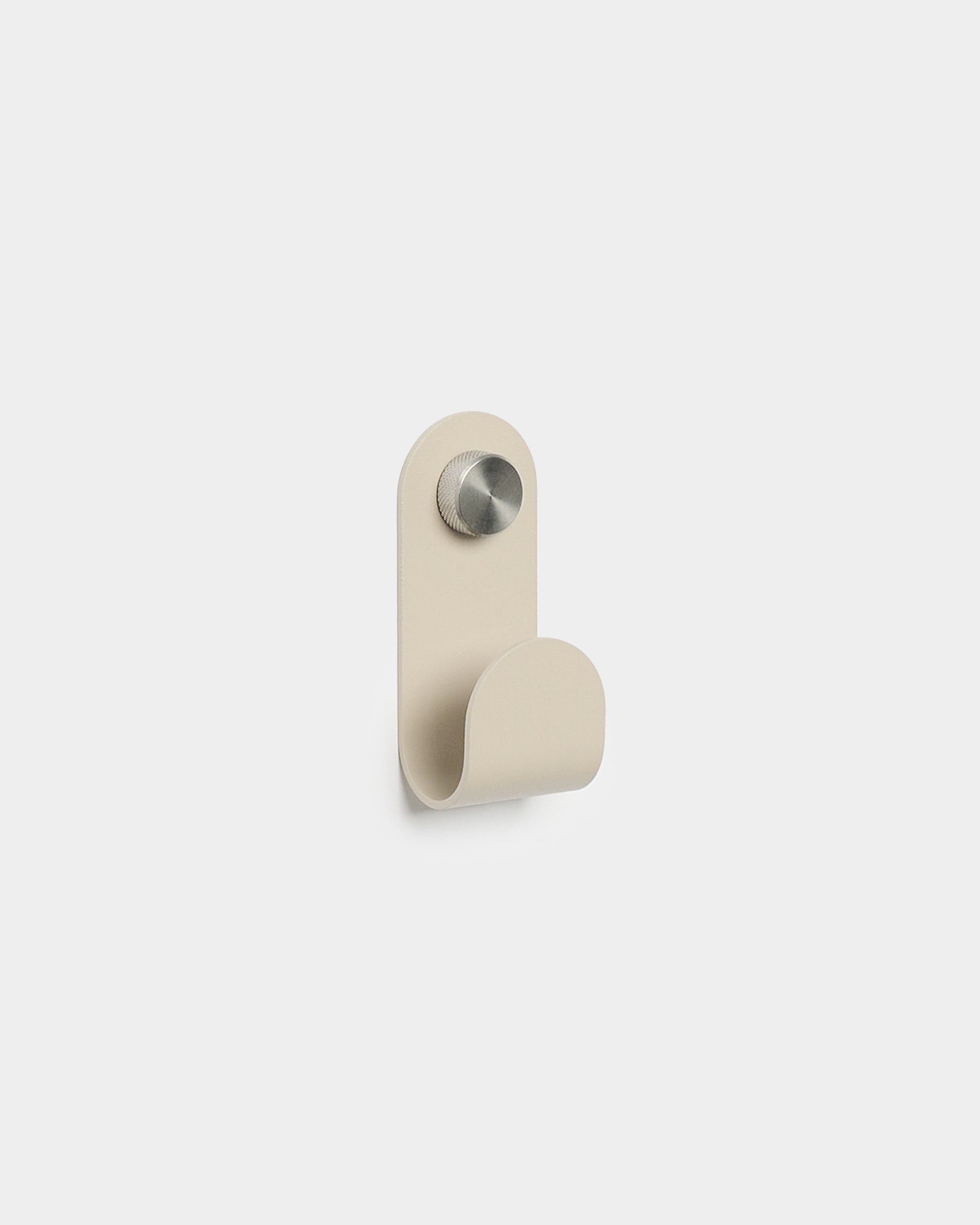 WoodUpp Norr Single Hanger in beige with a minimalist curved shape and brushed metal finish, designed as an accessory for compact Akupanel wall hooks.