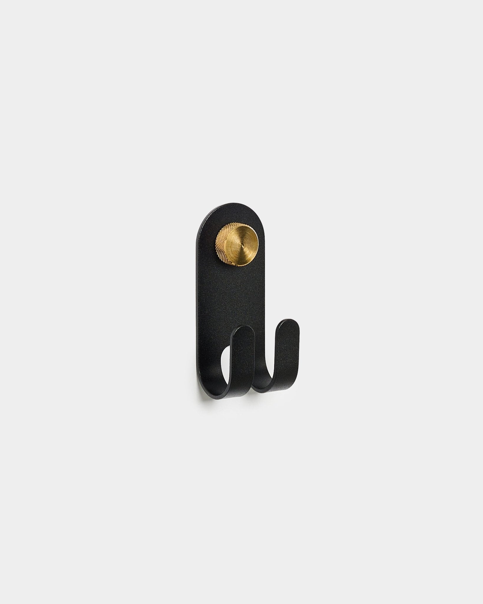 WoodUpp Norr Double Hanger in black, featuring two hooks and a round brass accent, displayed on a plain white background.