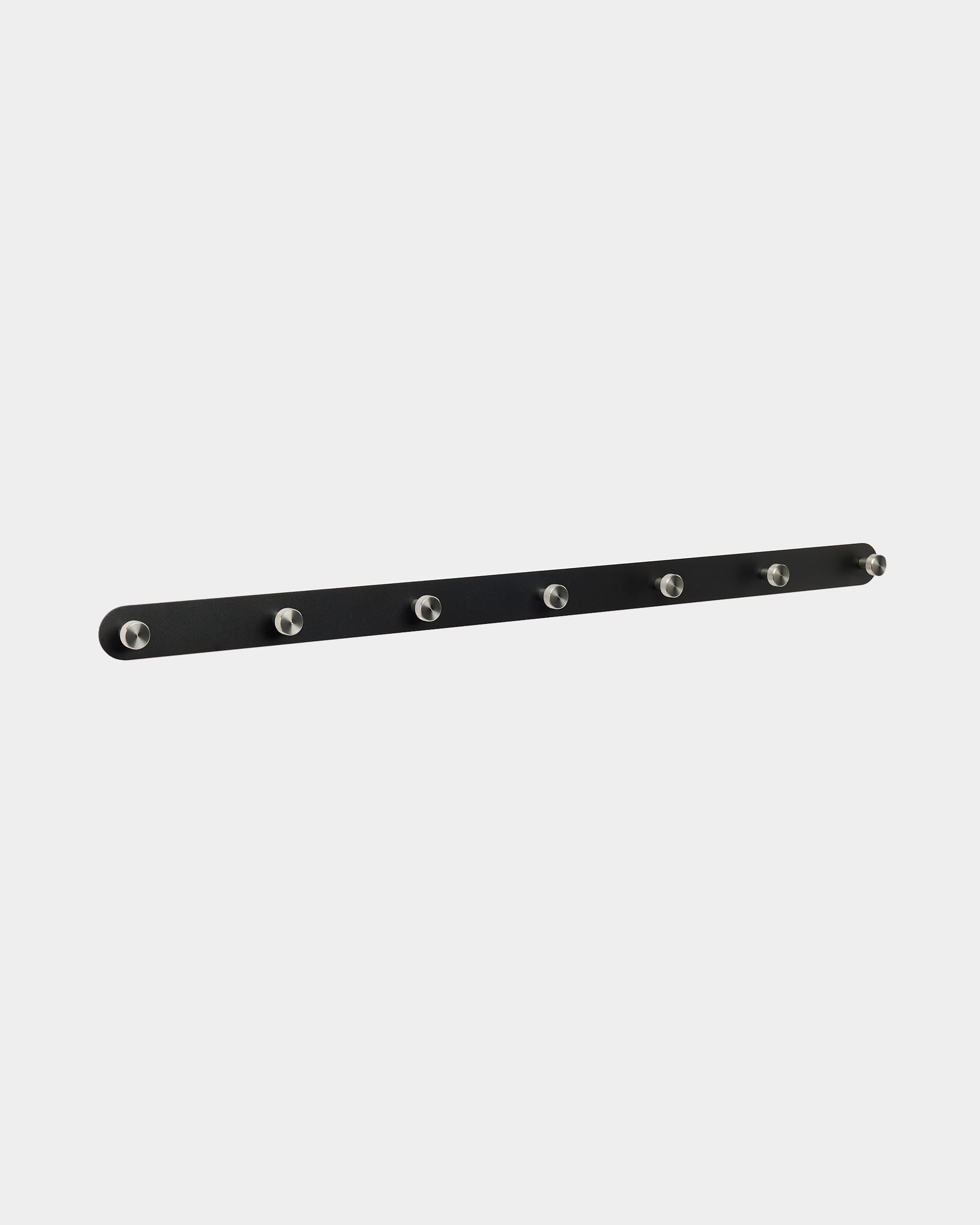 WoodUpp Norr Coat Hook Rack features a black Nordic design with 7 silver hooks, designed to complement Akupanel acoustic panels in entryways or hallways.