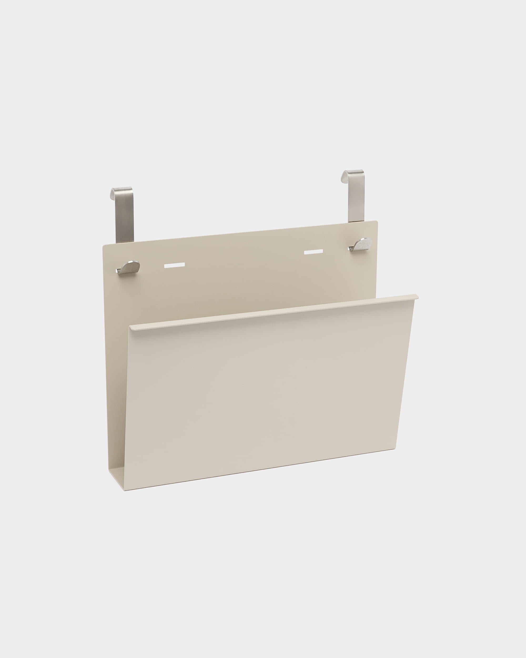 Nell Magazine Storage by WoodUpp is a beige powder-coated steel holder with two silver hooks for hanging on Nordic acoustic room dividers or partitions.