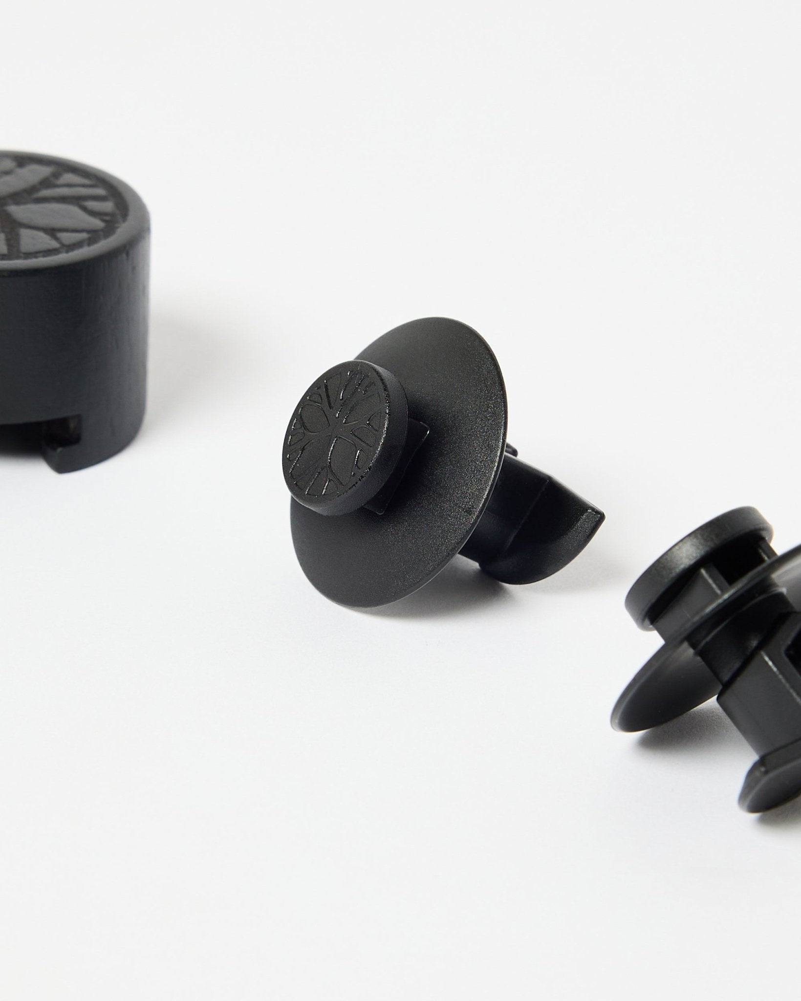 Set of 3 black nylon brackets with circular tops and installation tool, designed for mounting WoodUpp acoustic panels or slatwall panels.
