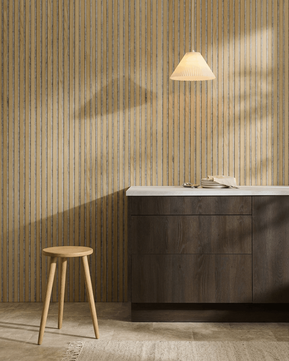 Minimalist Nordic interior featuring a WoodUpp Akupanel acoustic panel in Classic Oak with Grey Felt, paired with a wooden stool, dark cabinet, and white countertop.