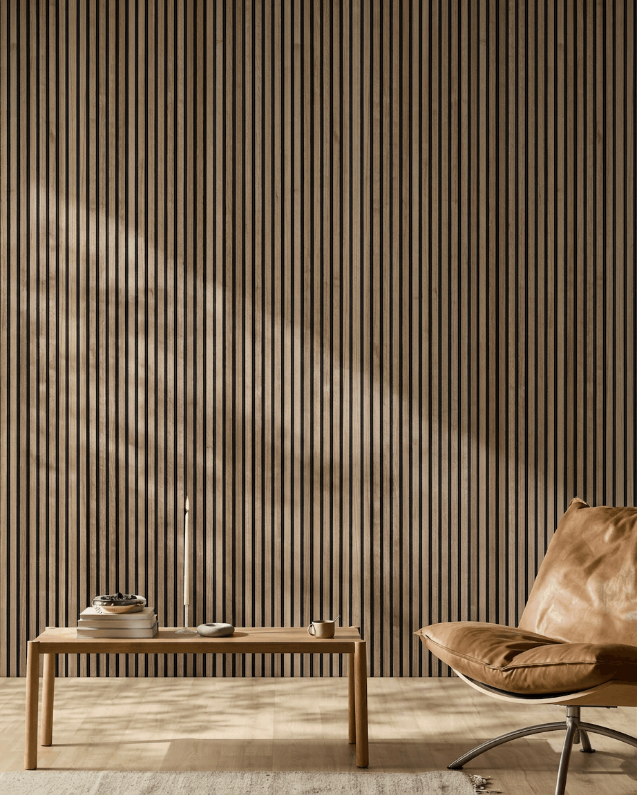 Minimalist Nordic room with walnut WoodUpp Akupanel acoustic wood panel, tan leather chair, and wooden coffee table holding books and a candle.